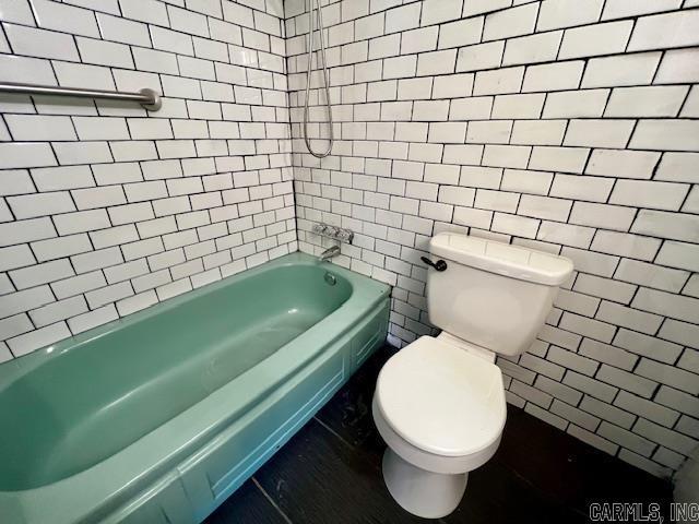 bathroom with tiled shower / bath and toilet