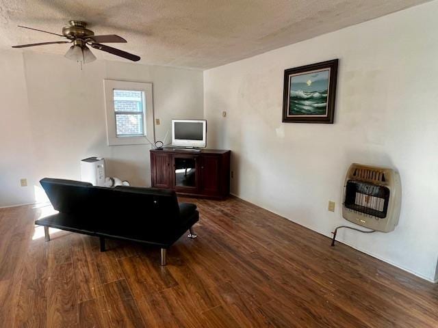 interior space featuring heating unit, ceiling fan, hardwood / wood-style flooring, and a textured ceiling