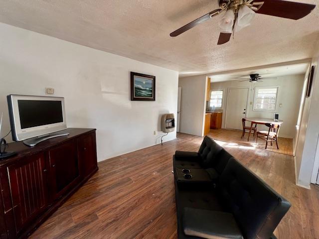 living room featuring hardwood / wood-style floors, heating unit, and a textured ceiling