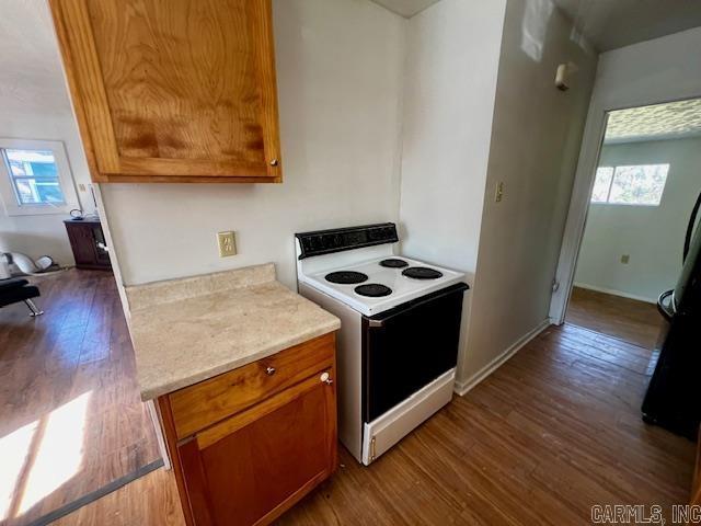 kitchen with white electric stove, plenty of natural light, and hardwood / wood-style flooring