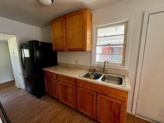 kitchen featuring black refrigerator, sink, and light wood-type flooring