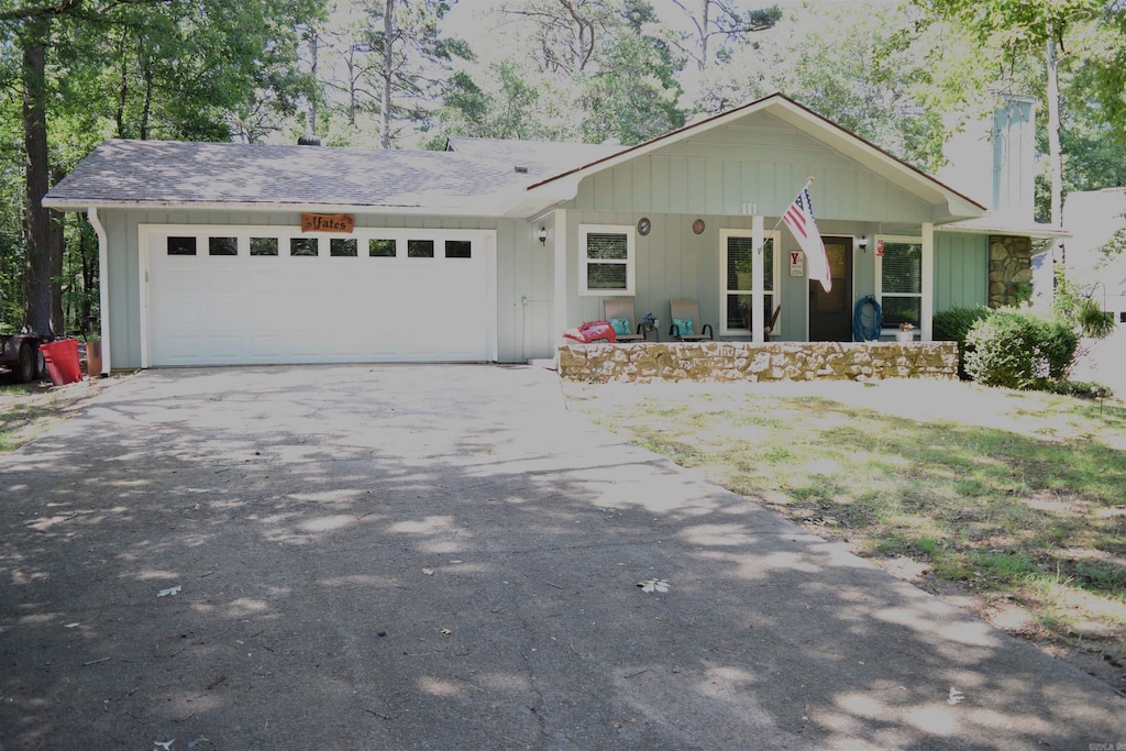 single story home featuring a porch and a garage