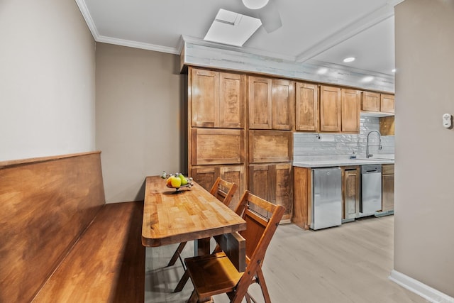 kitchen featuring tasteful backsplash, dishwasher, sink, fridge, and crown molding