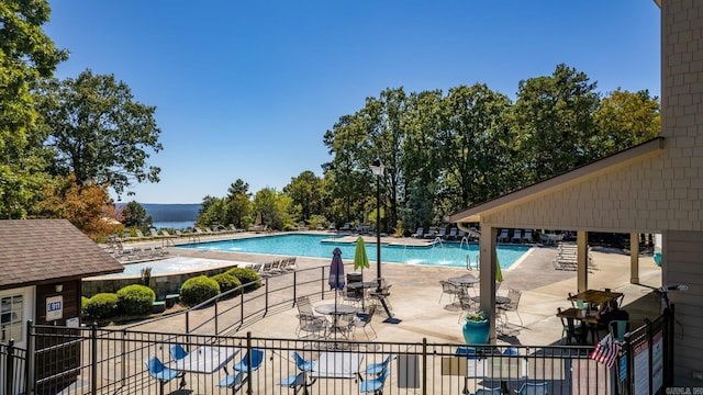 view of swimming pool with a patio and a water view