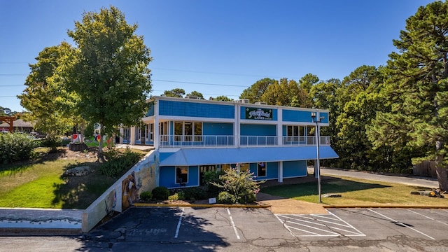 view of front of house featuring a balcony and a front yard