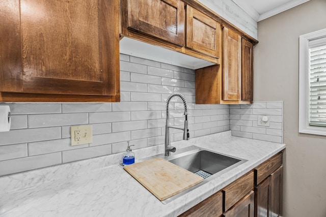 kitchen with crown molding, sink, and backsplash