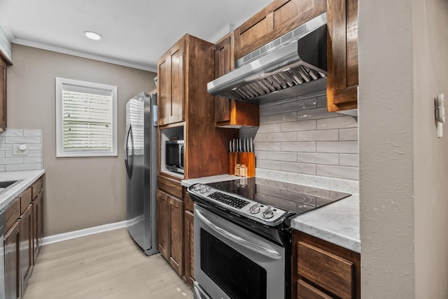 kitchen featuring stainless steel appliances, crown molding, backsplash, and light wood-type flooring