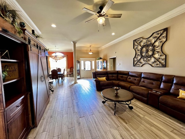 living room with decorative columns, ceiling fan, light hardwood / wood-style floors, crown molding, and a barn door