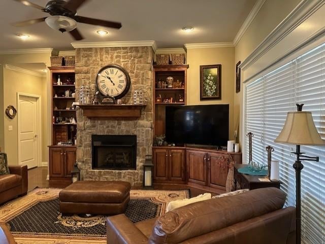 living room with ornamental molding, a fireplace, and a ceiling fan