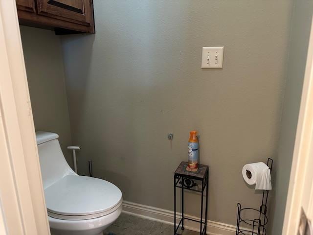 bathroom with baseboards and toilet