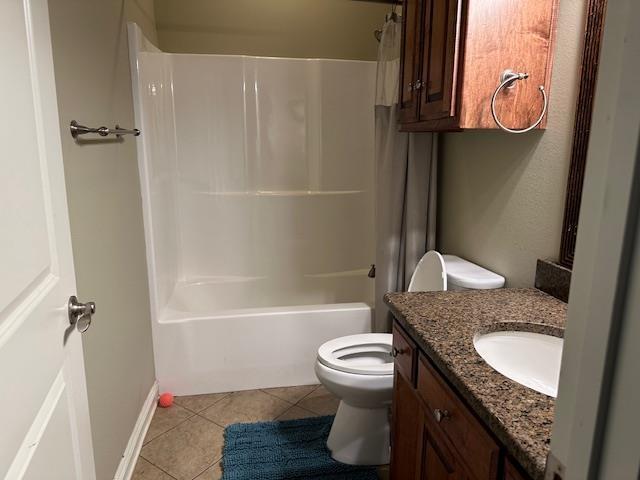 full bath featuring toilet, tile patterned floors, vanity, baseboards, and shower / tub combo with curtain