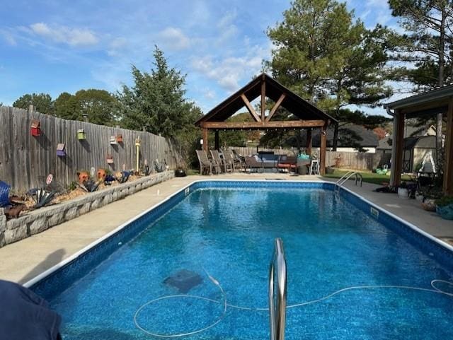 view of pool featuring a fenced backyard, an outdoor hangout area, a patio, and a gazebo