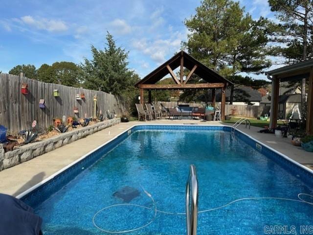 view of swimming pool featuring a patio area, outdoor lounge area, a fenced backyard, and a gazebo