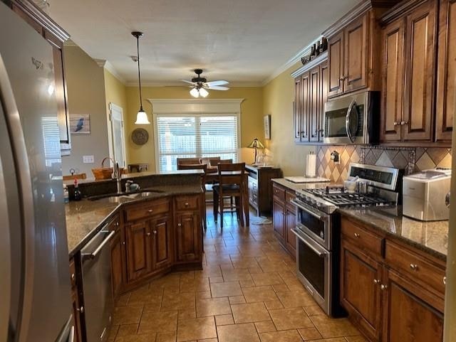 kitchen with ornamental molding, stainless steel appliances, tasteful backsplash, and a sink