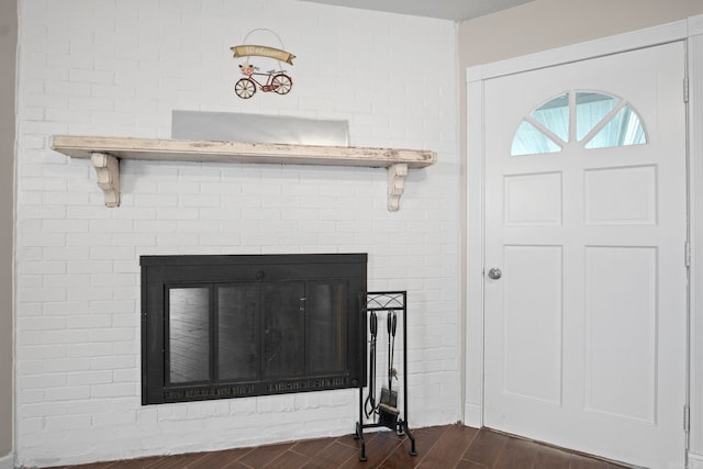 interior details featuring wood-type flooring and a brick fireplace