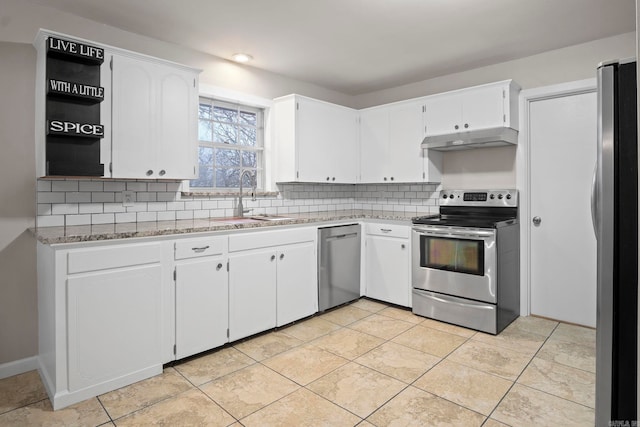 kitchen featuring appliances with stainless steel finishes, white cabinetry, sink, backsplash, and light stone countertops