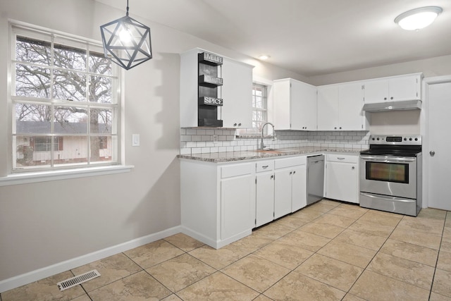 kitchen with white cabinetry, decorative light fixtures, light tile patterned floors, appliances with stainless steel finishes, and backsplash