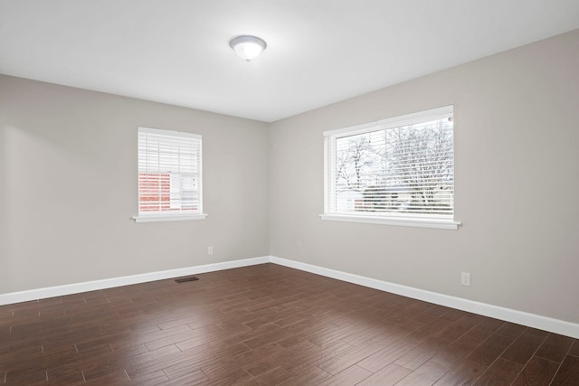 empty room with dark hardwood / wood-style flooring