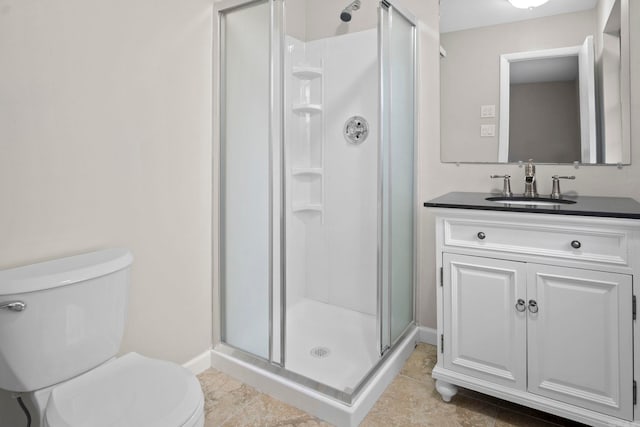 bathroom with vanity, a shower with door, and toilet