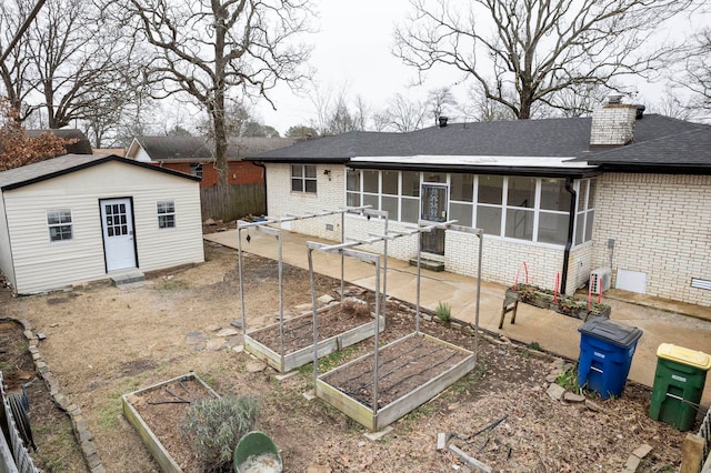 back of house featuring an outdoor structure and a sunroom