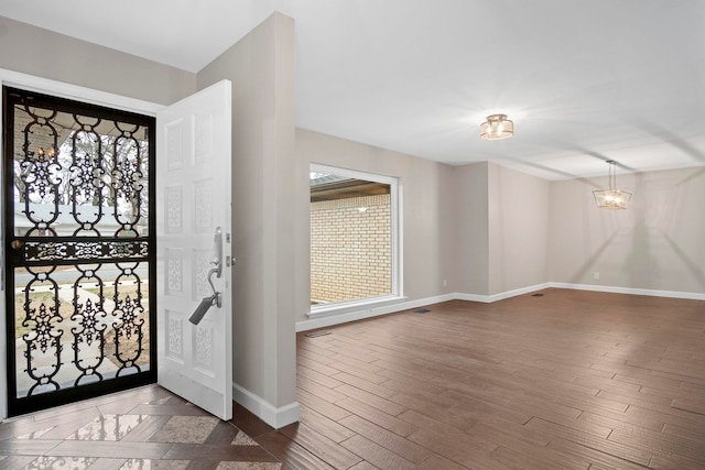 foyer entrance featuring dark wood-type flooring and a chandelier