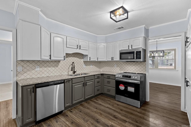 kitchen featuring sink, dark wood-type flooring, stainless steel appliances, and light stone countertops