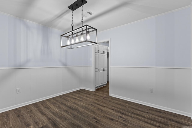 unfurnished dining area featuring dark wood-type flooring and ornamental molding