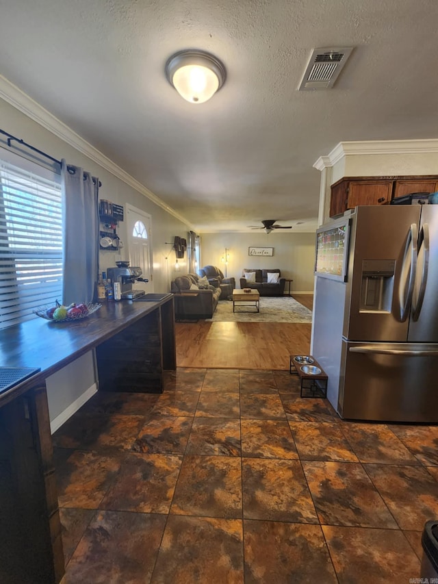 kitchen featuring ceiling fan, ornamental molding, a textured ceiling, and stainless steel refrigerator with ice dispenser