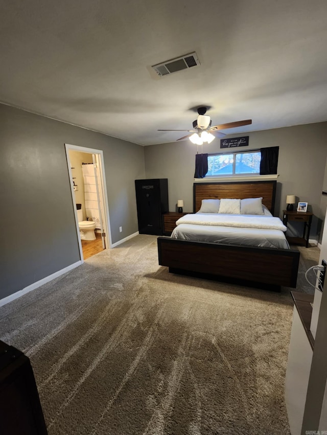 carpeted bedroom with ensuite bathroom and ceiling fan