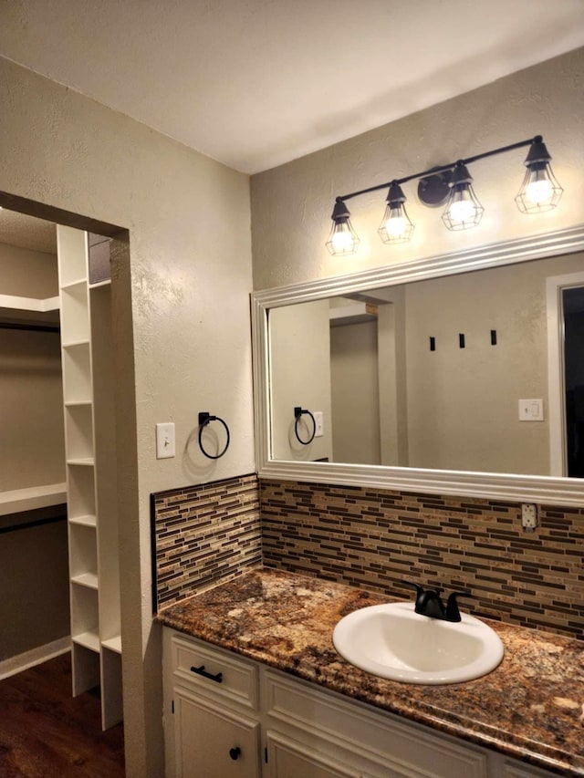 bathroom with tasteful backsplash, vanity, and hardwood / wood-style flooring