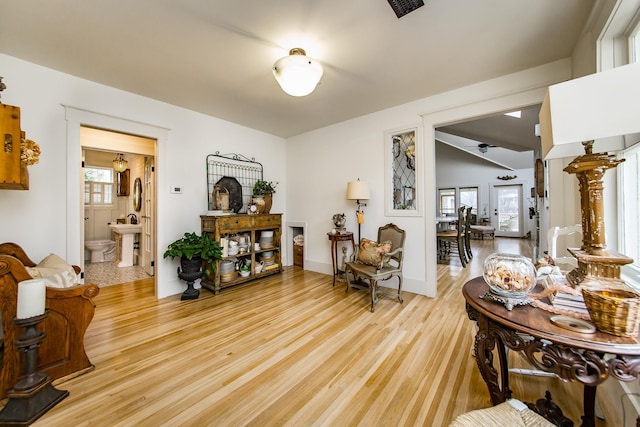 living room featuring vaulted ceiling and light hardwood / wood-style floors