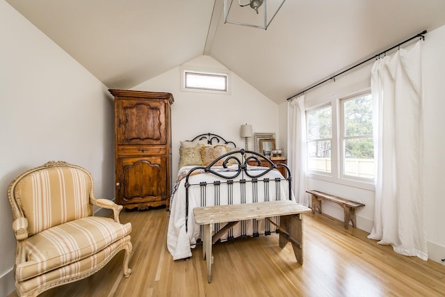 bedroom featuring lofted ceiling, light hardwood / wood-style floors, and multiple windows