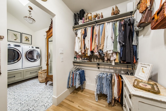 walk in closet with lofted ceiling, washer and dryer, and light hardwood / wood-style floors