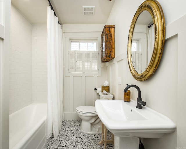 full bathroom featuring sink, tile patterned floors, shower / bath combination with curtain, and toilet