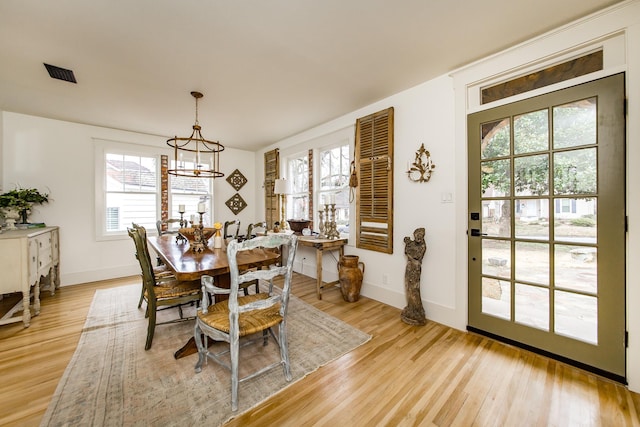 dining room with light hardwood / wood-style flooring and a chandelier