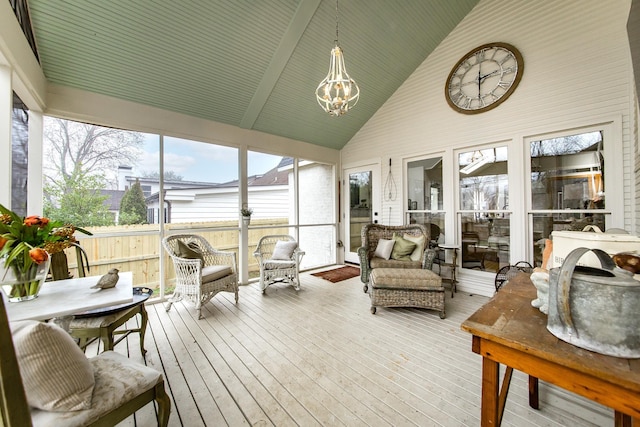 sunroom / solarium featuring a chandelier and vaulted ceiling