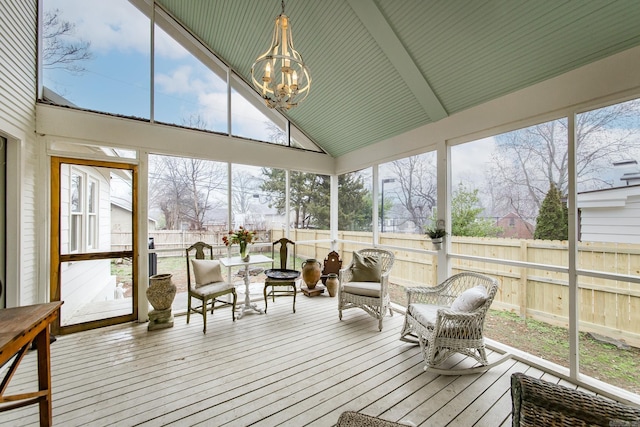 sunroom / solarium with lofted ceiling, a chandelier, and plenty of natural light