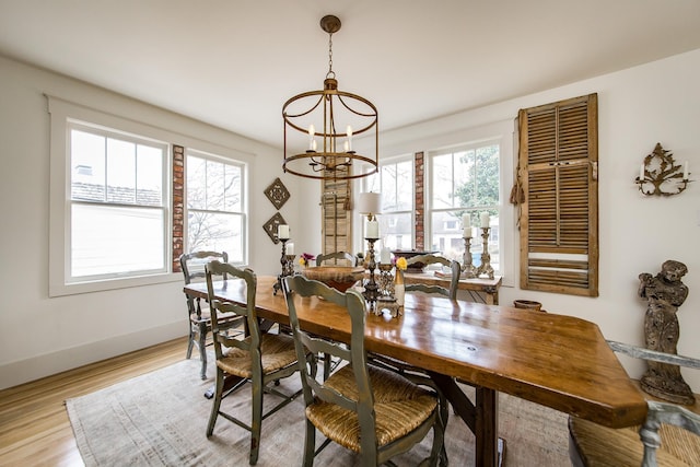 dining area with a notable chandelier and light hardwood / wood-style flooring