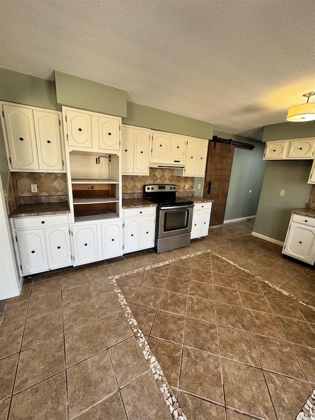 kitchen featuring tasteful backsplash, white cabinetry, stainless steel range with electric cooktop, dark tile patterned flooring, and a barn door