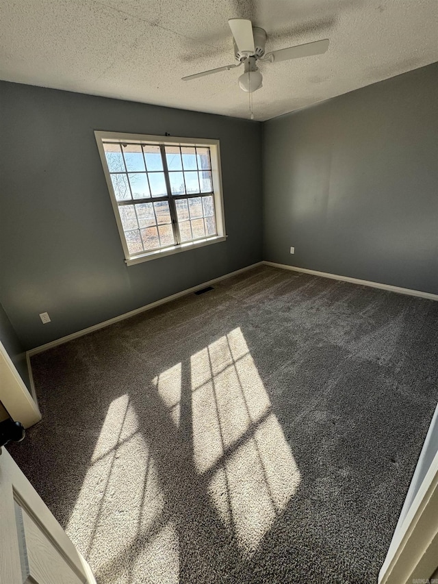 spare room featuring ceiling fan, carpet flooring, and a textured ceiling