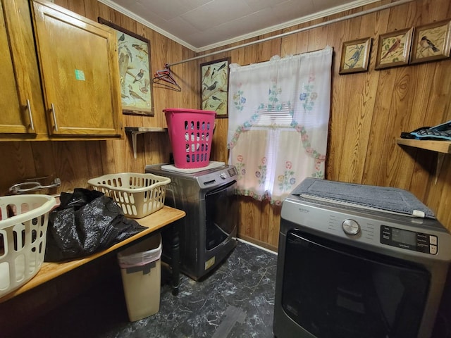 washroom featuring independent washer and dryer, cabinets, ornamental molding, and wood walls