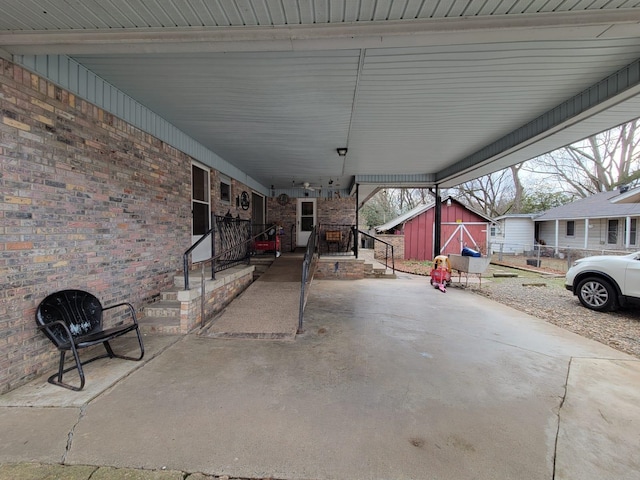 view of patio with a carport and a shed