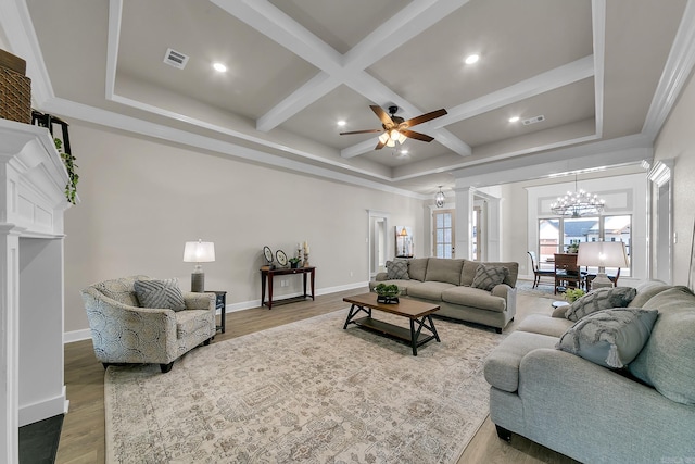 living room featuring ceiling fan with notable chandelier, coffered ceiling, hardwood / wood-style floors, and beam ceiling