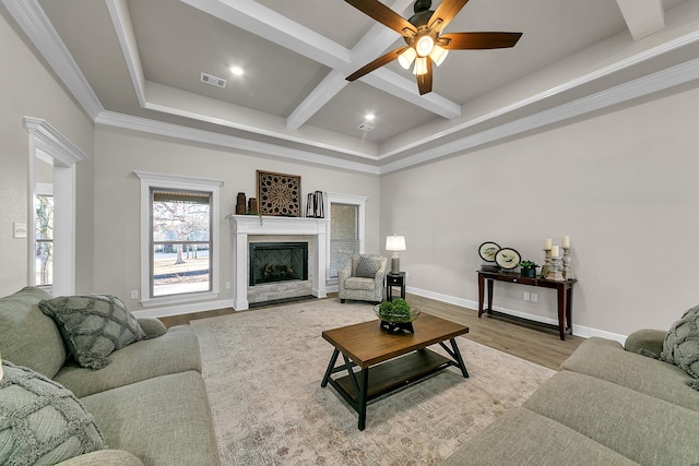 living room featuring a fireplace, beamed ceiling, wood-type flooring, coffered ceiling, and ceiling fan