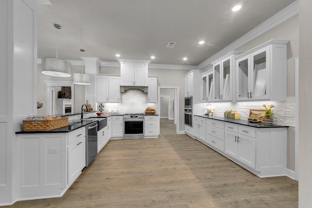 kitchen with appliances with stainless steel finishes, pendant lighting, sink, white cabinets, and kitchen peninsula