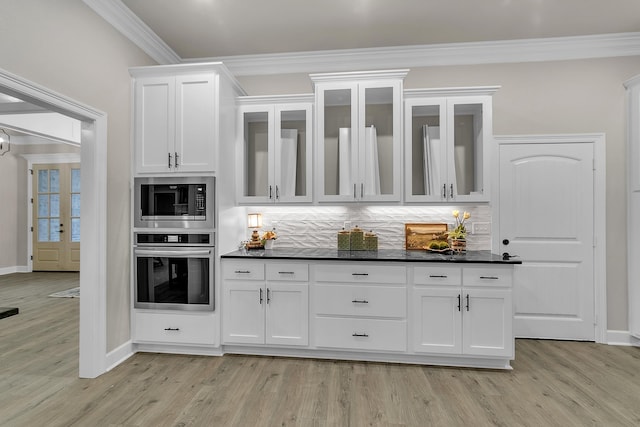 bar with built in microwave, white cabinetry, stainless steel oven, crown molding, and light wood-type flooring