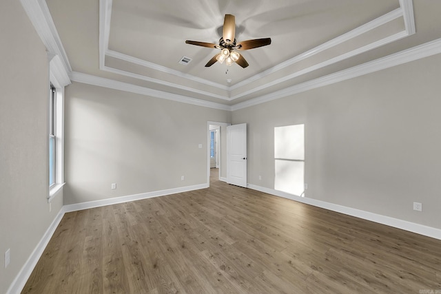 spare room with hardwood / wood-style flooring, ceiling fan, and a raised ceiling