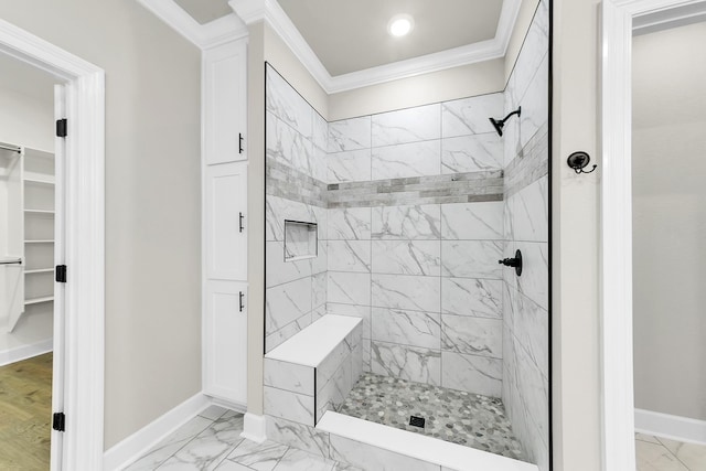 bathroom with ornamental molding and a tile shower