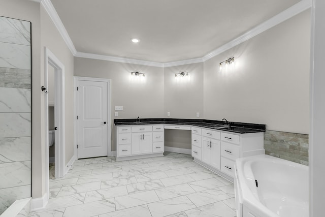 bathroom featuring ornamental molding, vanity, and a bathing tub