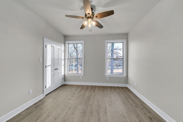 empty room with ceiling fan and light wood-type flooring